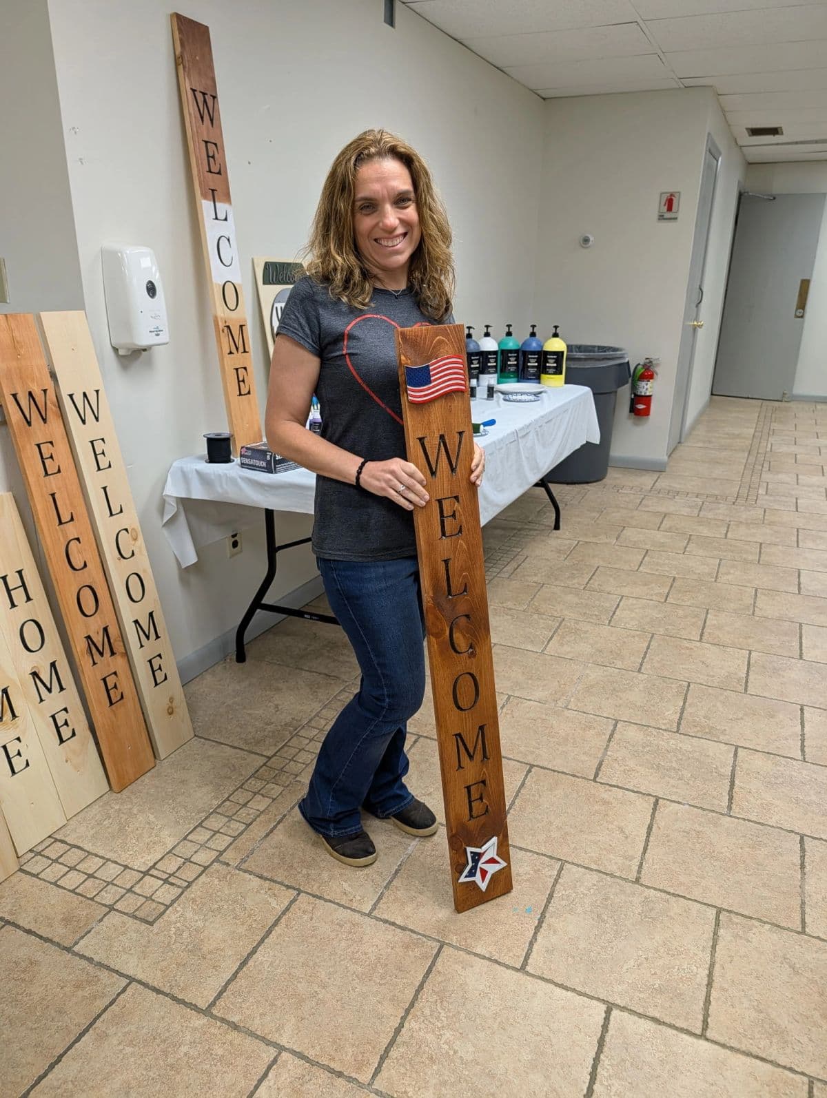 A community member with the wooden sign she made at a PTC workshop